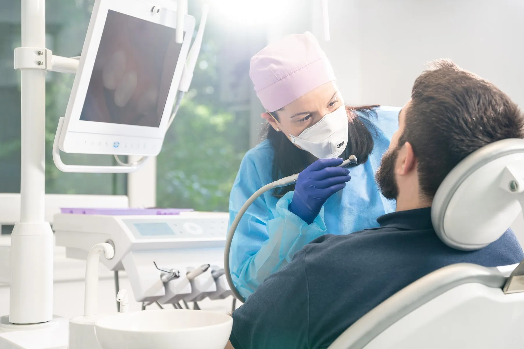 Dr. Roxana Usturoi examinează un pacient la unitul dentar